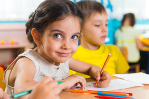 Group of cute little prescool kids drawing with colorful pencils